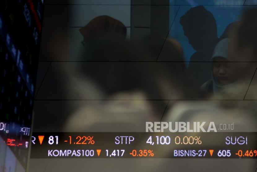 Pengunjung berada di dekat layar elektronik Indeks Harga Saham Gabungan (IHSG) di Gedung Bursa Efek Indonesia (BEI) Jakarta.