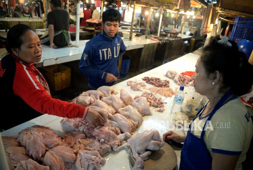 Pedagang melayani pembeli daging ayam potong di Pasar Senen, Jakarta, Ahad (14/1).