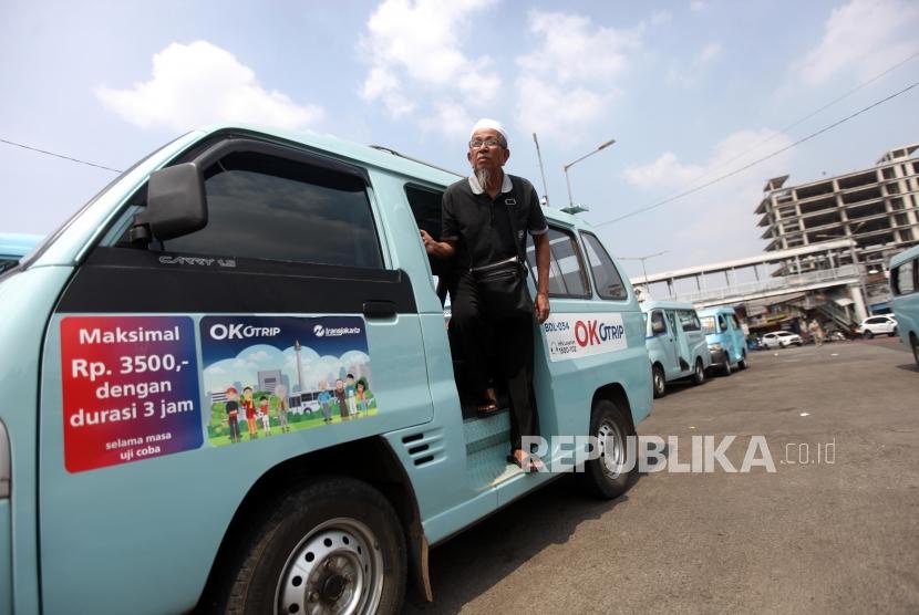 Penumpang turun dari angkutan umum dengan menggunakan kartu Ok-Otrip di Terminal Kampung Melayu, Jakarta, Senin (9/7).