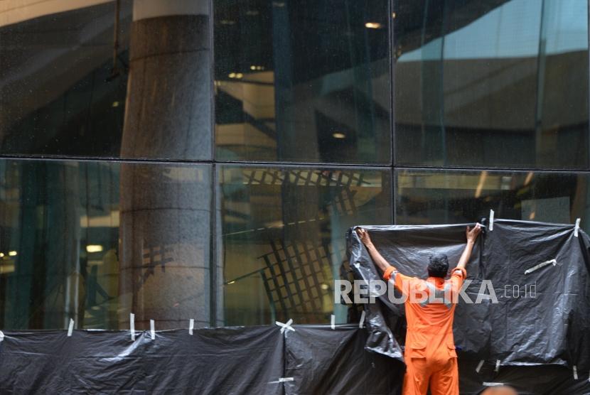 Selasar Ambruk. Petugas menutup kaca depan lobby usai ambruknya selasar di Tower II BEI, Jakarta, Senin (15/1).