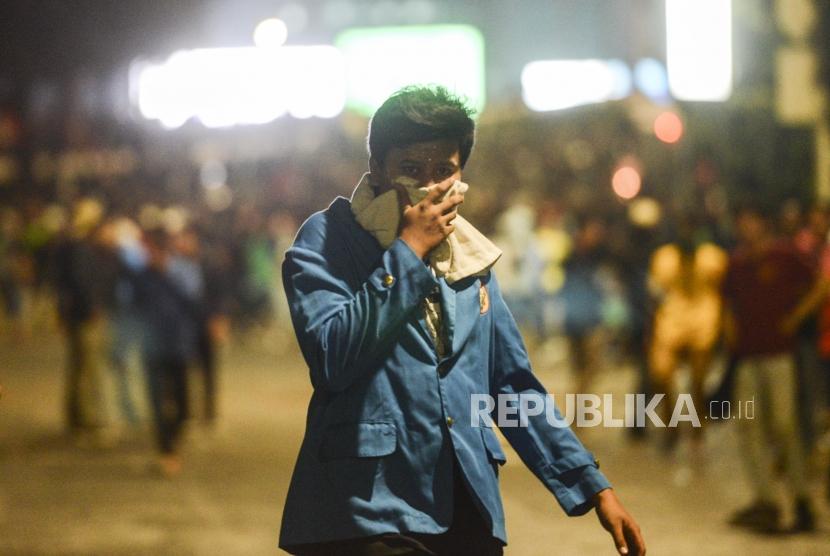 Sejumlah mahasiswa menutup hidung usai ditembakan gas air mata di depan Gedung DPR, Jakarta, Selasa (24/9).