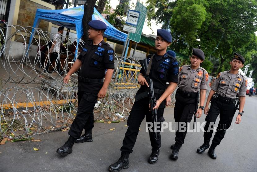 Anggota kepolisian berkeliling melakukan pengamanan di depan Gedung KPU, Jakarta, Ahad (19/5).