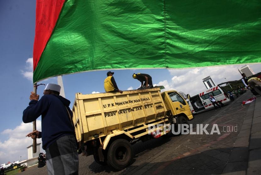 Sejumlah petugas mengangkut sampah menggunakan truk di Area Monumen Nasional, Jakarta, Jumat (11/5).