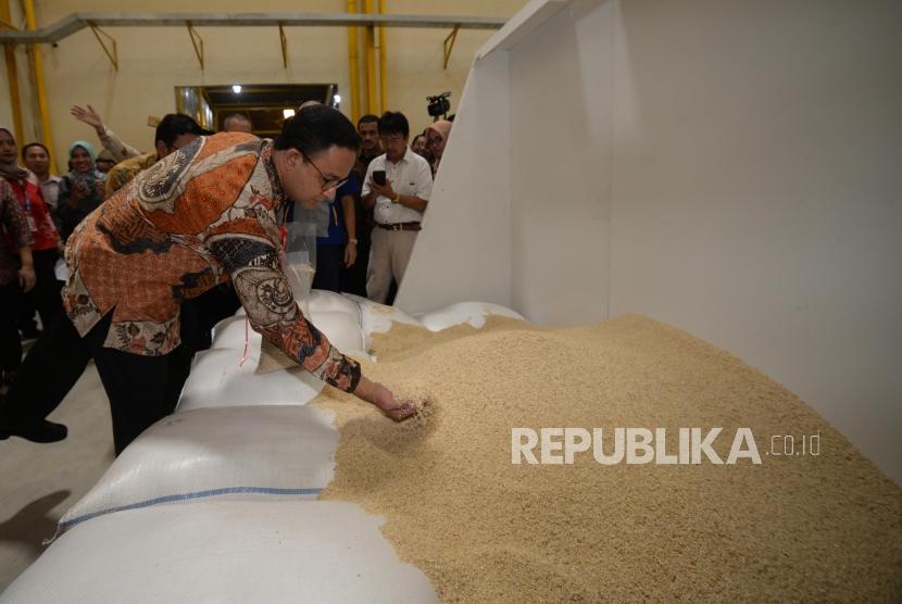 Gubernur DKI Jakarta Anies Baswedan melhat beras pecah kulit saat peresmian mesin pengolah beras di Pergudangan Pasar Induk Beras Cipinang, Jakarta, Kamis (20/12).