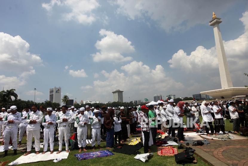 Umat muslim melaksanakan shalat jumat seusai mengikuti aksi Indonesia Bebas Al-Quds 115 di Monumen Nasional, Jakarta, Jumat (11/5).