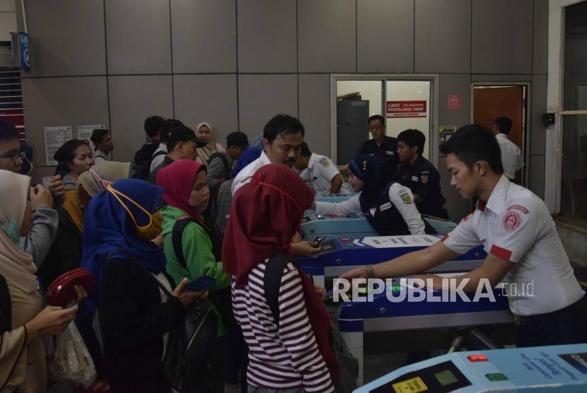 Petugas KRL membantu penumpang saat akan menggunakan tiket elektronik di Statsiun Manggarai, Jakarta, Senin (23/7).