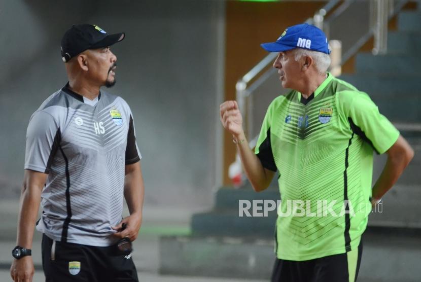 Pelatih Persib Bandung, Roberto Carlos Mario Gomez (kanan) berdiskusi dengan asisten pelatih Herrie Setyawan saat latihan fisik pemain Persib di Gor Pajajaran, Kota Bandung, Senin (5/3).