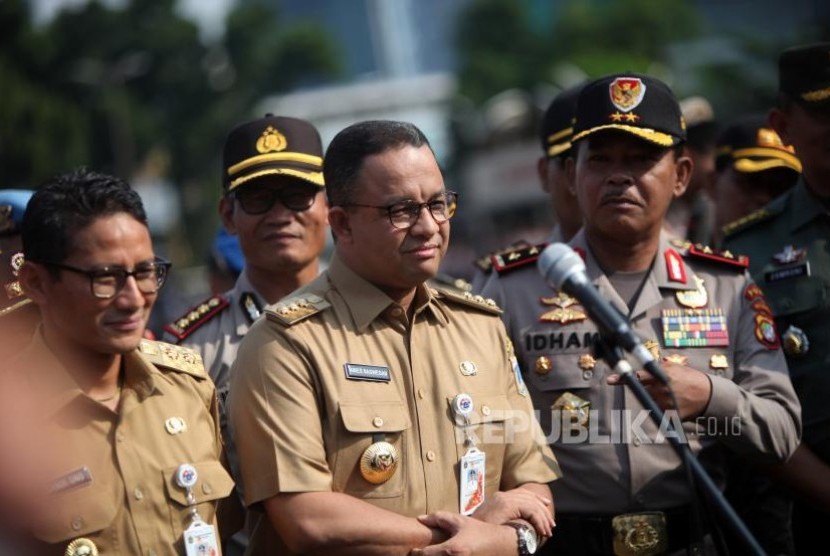 Gubernur DKI Jakarta Anies Baswedan (tengah) bersama Wakil Gubernur DKI Jakarta Sandiaga Salahudin Uno (kiri) 