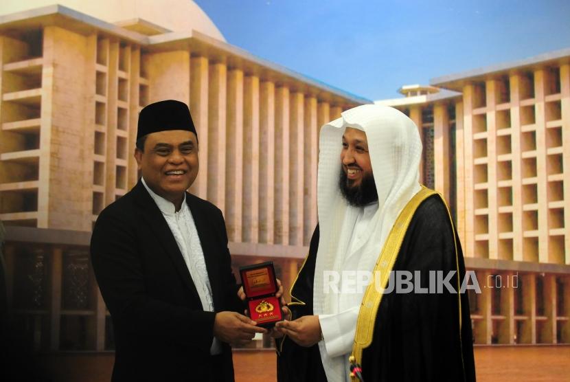 Wakil Ketua Umum Dewan Masjid Indonesia (DMI) yang juga Wakapolri Komjen Pol Syafruddin (kiri) bersama Imam Masjidil Haram Syekh Hasan Abdul Hamid Bukhari memberikan cinderamata usai pertemuan di Kantor DMI, Kebayoran Baru, Jakarta, Rabu (4/7).