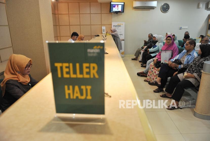Petugas Bank Mandiri Syariah melayani calon jemaah haji yang melakukan pelunasan Biaya Penyelenggaran Ibadah Haji (BPIH) di Kantor Cabang Mandiri Syariah Area Bekasi, di Bekasi, Jawa Barat, Senin (16/4).
