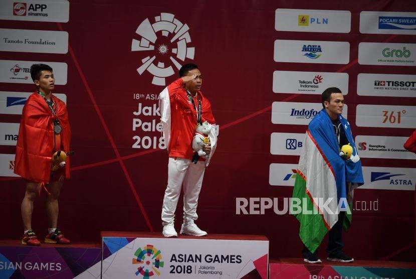 Lifter Indonesia  Eko Yuli  Irawan melakukan penghormatan kepada bendera sang merah putih dalam upacara penyerahan medali di cabang angkat besi putra nomor 62 Kg Asian Games 2018 di Hall A Kemayoran, Jakarta, selasa (21/8).
