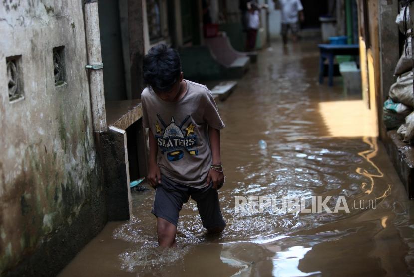 Warga menerobos banjir di Kebon Pala, Kampung Melayu, Jakarta, Senin (21/5).