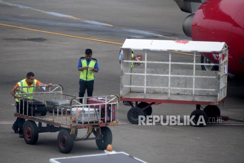 Petugas masukan barang milik penumpang ke bagasi pesawat di Bandara Internasional Soekarno-Hatta, Tanggerang,Banten, Kamis (7/2).