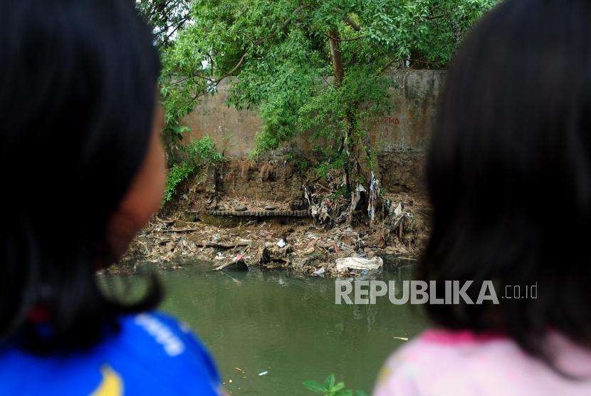 Anak-anak bermain di dekat  Sungai Ciliwung yang tercemar oleh sampah di kawasan Kebon Baru, Tebet, Jakarta, Jumat (7/9).