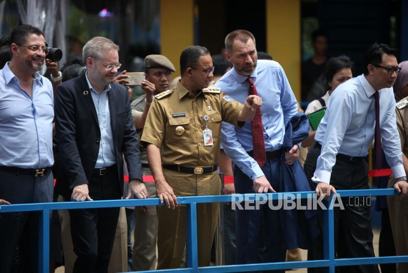 Gubernur DKI Jakarta Anies Baswedan (tengah) bersama Dubes Denmark Rasmus A Kristensen (kiri) dan Dubes Norwegia Vegard Kalee (kanan) berbincang saat meninjau kondisi sampah di Pintu Air Manggarai, Jakarta, Selasa (30/1).