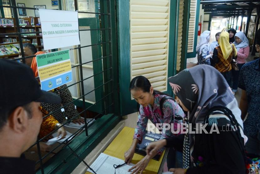 Sejumlah orang tua murid menandatangani daftar nama anaknya yang diterima di SMAN 5 Bandung, melalui jalur PPDB, di Jalan Belitung, Kota Bandung, Kamis (12/7).