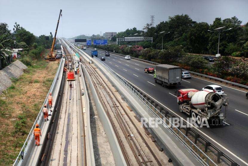 Pekerja menyelesaikan pemasangan rel Kereta Light Rail Transit (LRT) Jabodebek di kawasan Kampung Makassar, Jakarta, Selasa (28/8).