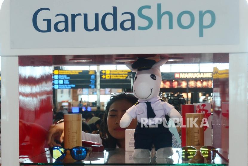 Seorang petugas GarudaShop sedang merapihkan merchandise eksklusif Garuda Indonesia disela acara peluncuran Garuda Shop JD.ID di Terminal 3 Bandara Soekarno Hatta, Cengkareng, Selasa (13/2).