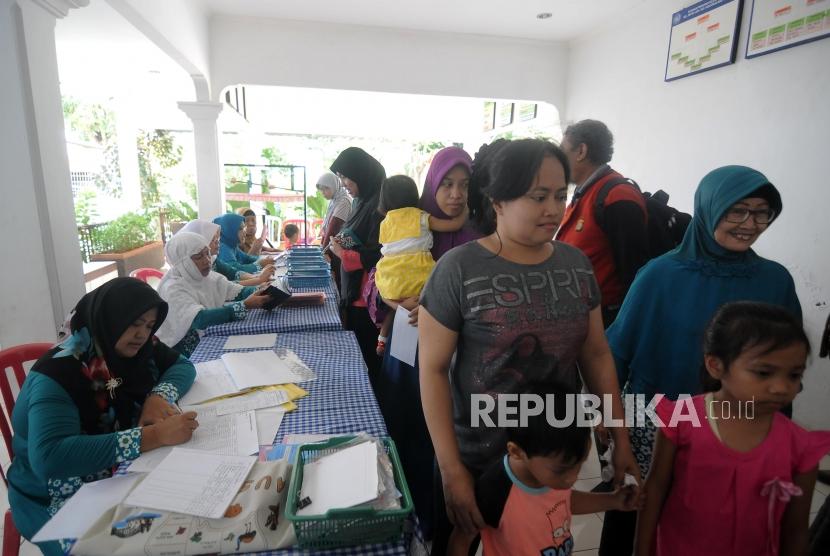 Imunisasi Massal Difteri. Sejumlah warga mengantre untuk melakukan imunisasi Difteri kepada anaknya di Posyandu Mawar, Pancoran Mas, Kota Depok, Jawa Barat, Senin (11/12).