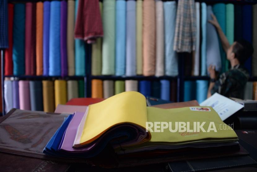 Karyawan menata gulungan kain tekstil di toko mutiara textile, Pasar Minggu, Jakarta,Jumat(7/12).