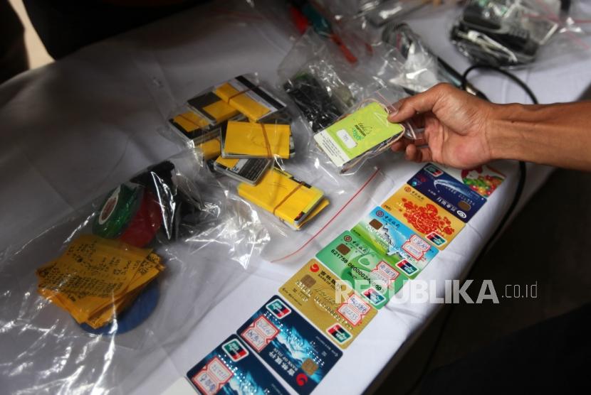 Petugas polisi memperlihatkan barang bukti saat rilis penungkapan kasus pencurian data elektronik (Skimming) dan pencucian uang jaringan internasional di Mapolda Metro jaya, Jakarta. (ilustrasi)