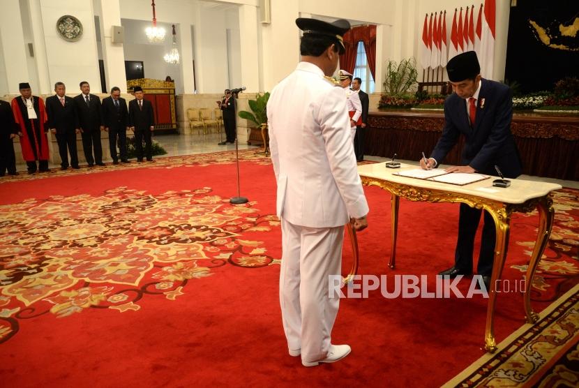 Pelantikan Wagub Kepri. Presiden Joko Widodo (kanan) mendatangani berita acara pelantikan di hadapan Wakil Gubernur Kepulauan Riau Isdianto di Istana Negara, Jakarta, Selasa (27/3).