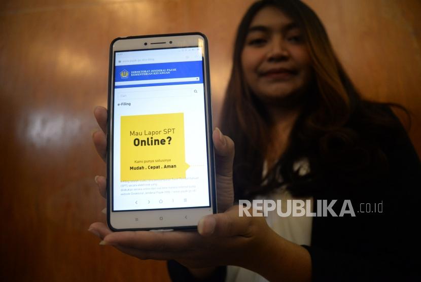 Seorang wajib pajak menunjukan informasi mengenai pengisian SPT secara online di Jakarta, Jumat (9/3).