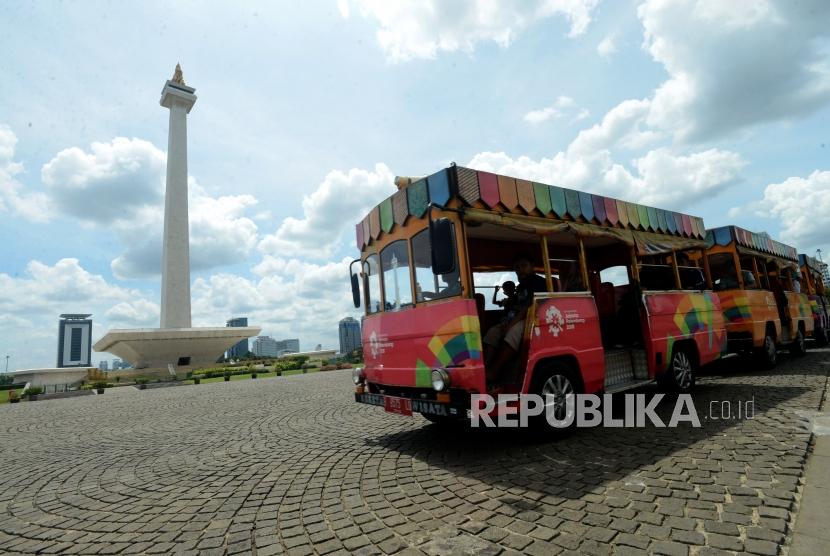 Pengunjung menaiki mobil di kawasan Monumen Nasional (Monas), Jakarta. Unit Pengelola Kawasan Monumen Nasional (Monas) menghentikan sementara layanan mobil wisata kawasan cagar budaya itu selama Pembatasan Sosial Berskala Besar (PSBB) transisi.