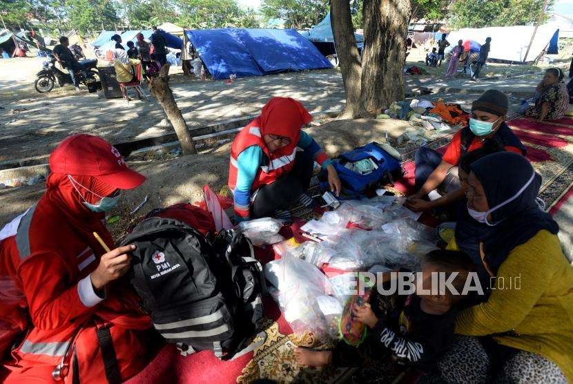 Sejumlah relawan menyiapkan obat usai memeriksa kesehatan pengungsi di Posko Pengungsian Masjid Agung Darussalam , Palu, Sulawesi Tengah, Jumat (5/10).