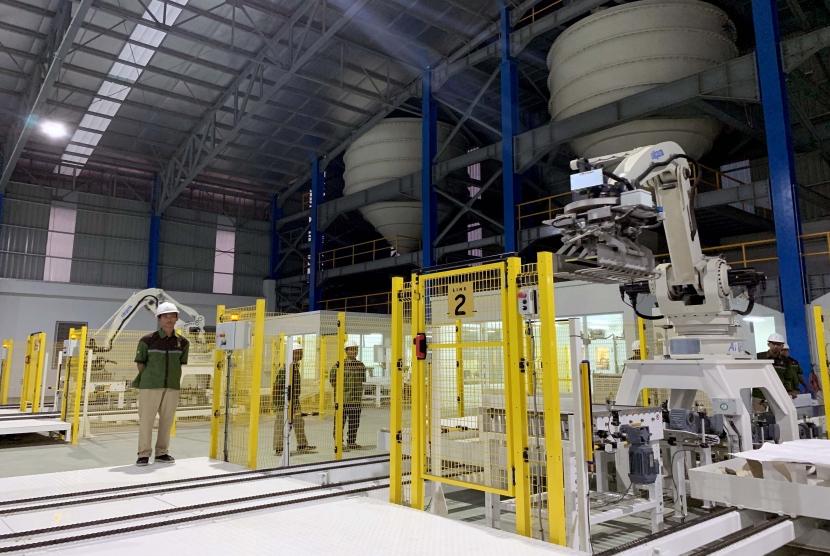 Pekerja beraktivitas di dekat robot pemroses gula tebu di Pabrik Gula (PG) Rejoso Manis Indo (RMI) di Blitar, Jawa Timur, Sabtu (24/8/2019).