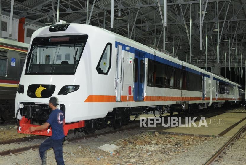 Pekerja melintas di depan kereta bandara Soekarno Hatta di Balai Yasa Manggarai, Jakarta Selatan, Jumat (24/11).