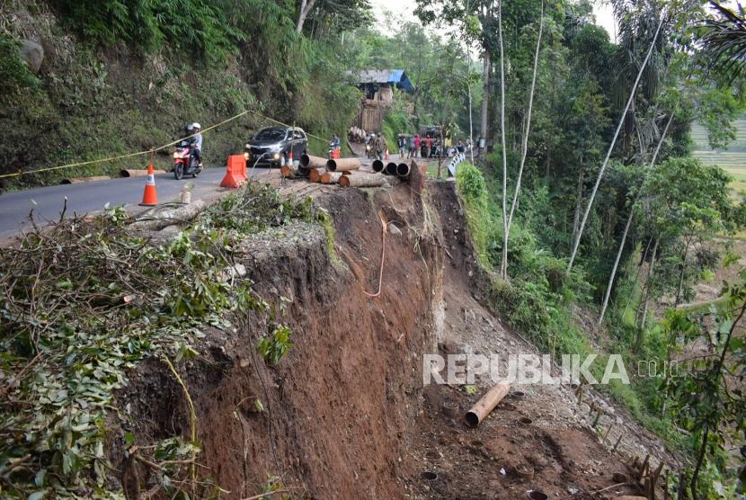 Sejumlah pekerja dari Dinas Bina Marga dan Penataan Ruang membenahi pinggiran jalan yang longsor di ruas jalan provinsi batas kabupaten Garut dan Tasikmalaya.