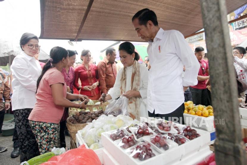 Presiden Joko Widodo beserta ibu negara Iriana Joko Widodo berbelanja buah di Pasar Sukawati, Gianyar, Bali, Jumat (14/6).