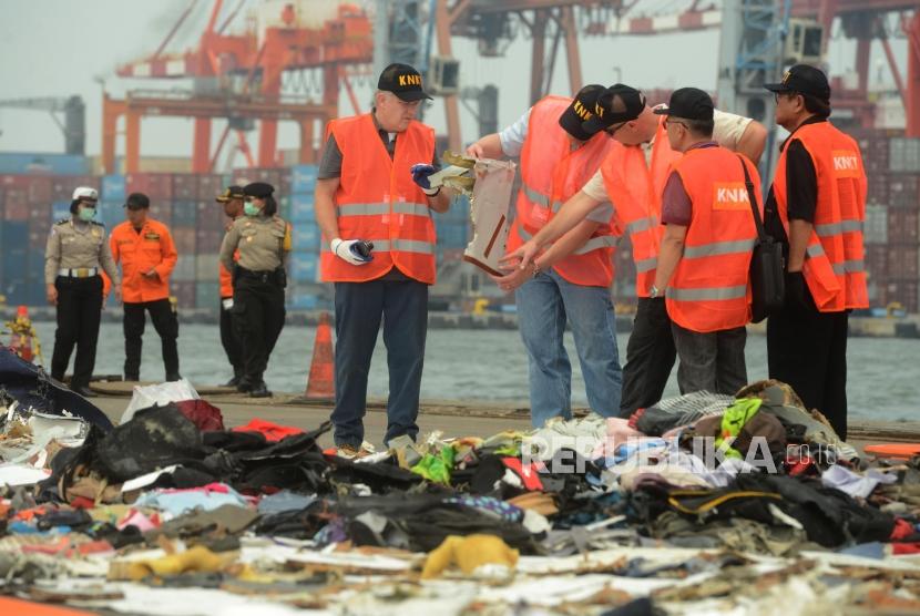 Penyelidik dari Komite Nasional Keselamatan dan Transportasi (KNKT) Indonesia dan Dewan Keselamatan Transportasi Nasional (NTSB) Amerika serikat saat memeriksa puing-puing pesawat Lion Air JT 610 di Terminal JICT 2, Tanjung Priok, Jakarta, Kamis (1/11).