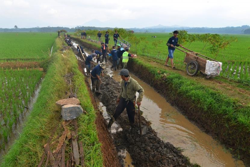 Sejumlah warga bergotong royong membangun saluran irigasi untuk mengairi lahan pesawahan di Desa Tanjungsari, Kabupaten Tasikmalaya, Jawa Barat, Sabtu (12/5).