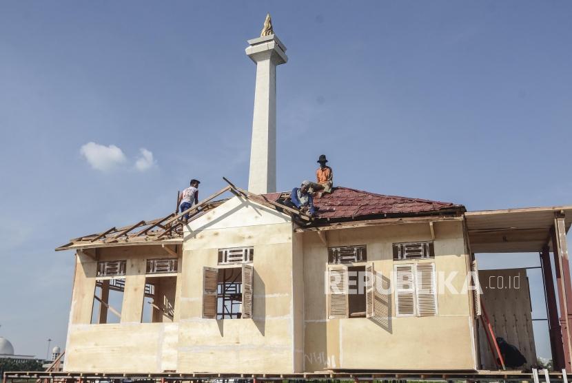 Persiapan Lebaran Betawi Monas. Pekerja menyelesaikan pembuatan replika rumah adat betawi di kawasan Monumen Nasional, Jakarta Pusat, Kamis (18/7).