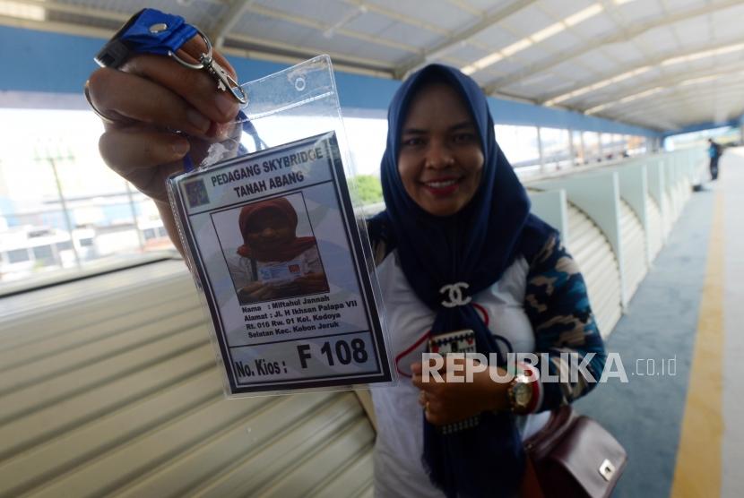 Pedagang memperlihatkan kartu identitas untuk berjualan di skybridge atau Jembatan Penyeberangan Multiguna (JPM) Tanah Abang, Jakarta, Jumat (7/12).