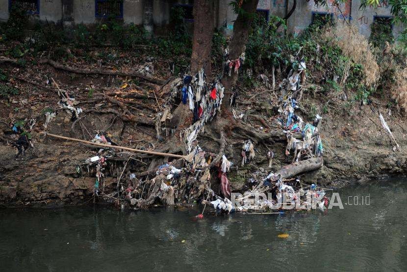 Sejumlah sampah plastik tersangkut di akar pohon yang terdapat pada aliran Sungai Ciliwung di kawasan Kebon Baru, Tebet, Jakarta, Jumat (7/9).