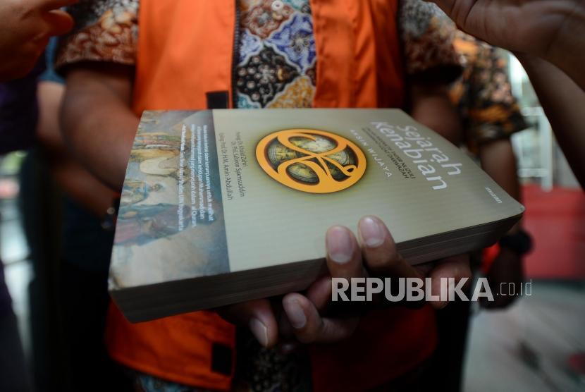 Buku yang digunakan untuk menutup tangan yang diborgol oleh tersangka kasus dugaan suap seleksi pengisian jabatan di Kementerian Agama Romahurmuziy usai menjalani pemeriksaan di Gedung KPK, Jakarta, Jumat (22/3).