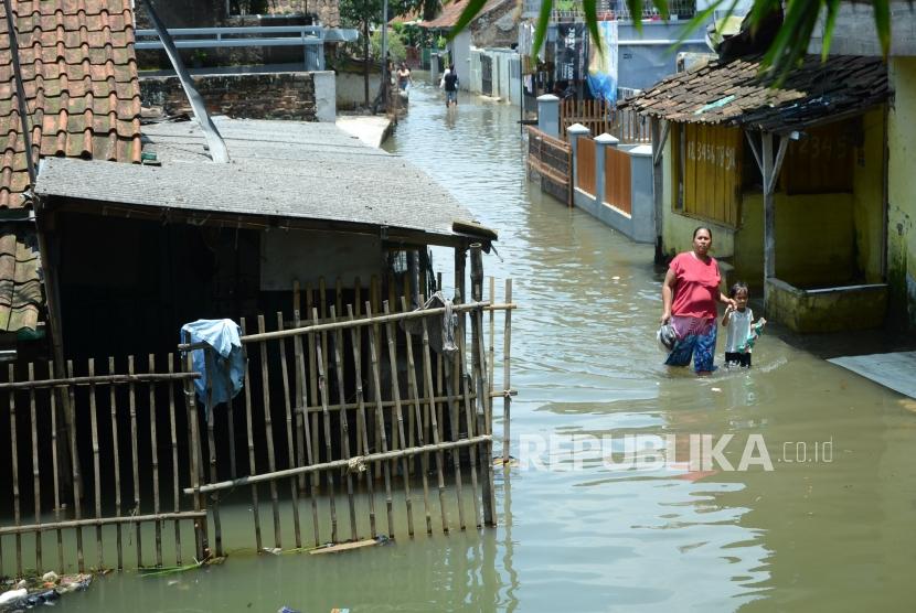 Banjir Bandung Selatan. Penduduk berjalan jalan kampung disebuah pemukiman yang telah terendam banjir, di Kecamatan Baleendah, Kabupaten Bandung, Senin (25/2).