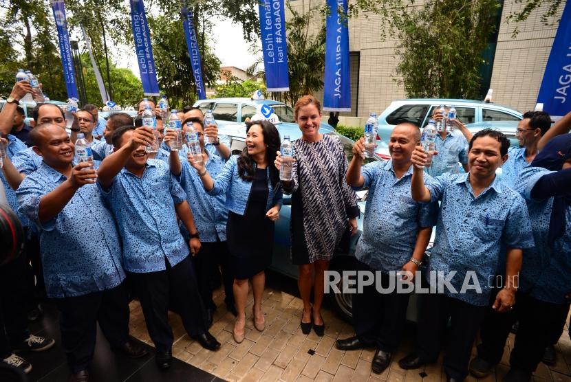 Presiden Direktur Blue Bird Group Holding Noni Purnomo dan Presiden Direktur PT.Tirta Investama (Danone-Aqua) Corine Tap (tengah) mengangkat botol air minum Aqua bersama pengemudi taksi Bluebird di Jakarta, Selasa (29/1).