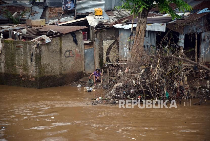 Warga berakitvitas di bantaran sungai Ciliwung di Jakarta, Senin (26/2).