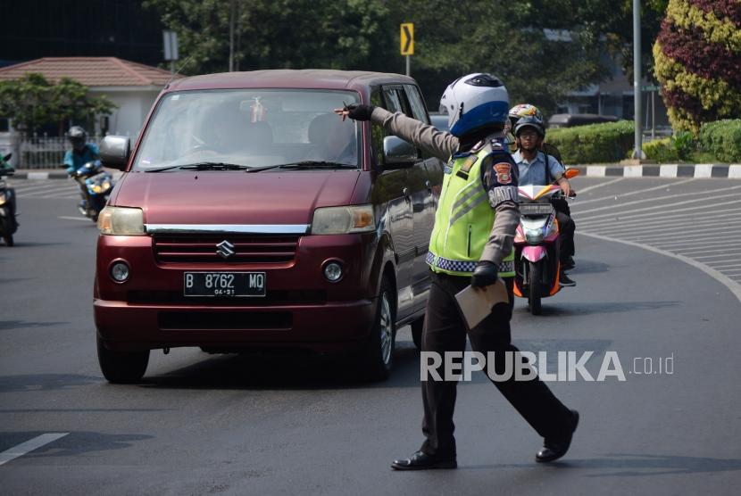 Petugas kepolisian mengamankan kendaraan roda empat di kawasan perluasan ganjil genap Jalan Majapahit, Jakarta, Senin (9/9/2019).