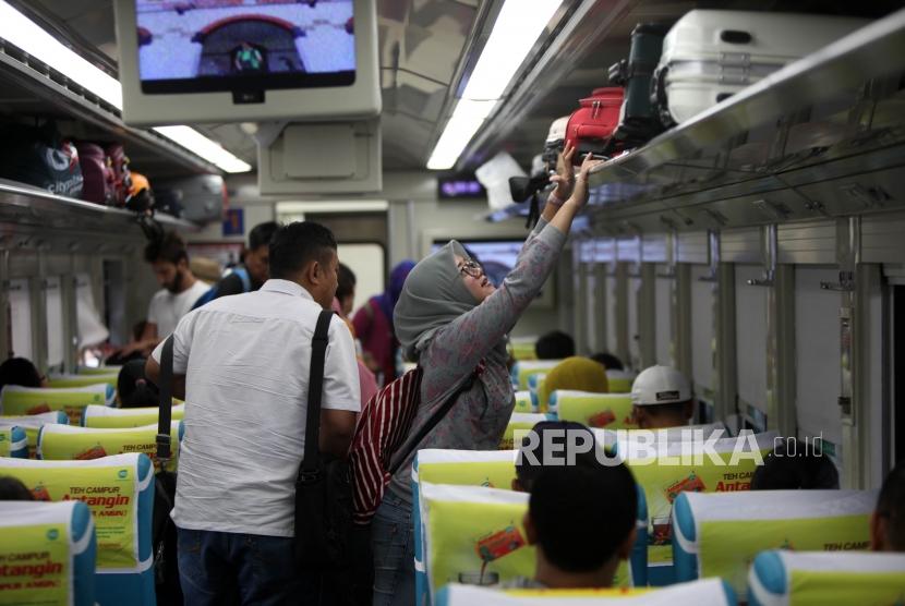 Seorang calon pemudik menyimpan barangnya dibagasi saat menaiki kereta api di Stasiun Gambir, Jakarta, Selasa (5/6).