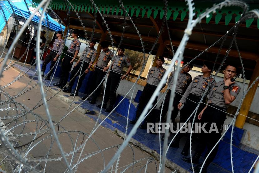 Anggota kepolisian saat melakukan pengamanan di depan Gedung KPU, Jakarta, Ahad (19/5).
