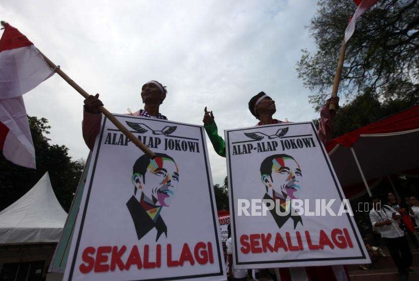 Relawan Jokowi-Ma'ruf Amin berkumpul untuk menunggu kedatangan capres petahana Joko Widodo bersama cawapres Ma'ruf Amin di Tugu Proklamasi, Jakarta, Jumat (21/9).