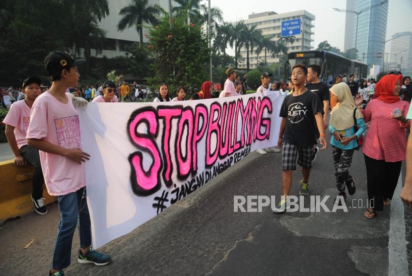 Relawan membentangkan spanduk  dalam acara Stop Bullying di  kawasan hari bebas kendaraan bermotor (HBKB) Bundaran Hotel Indonesia, Jakarta, Ahad (13/5).