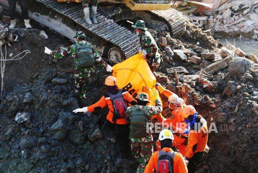 Anggota TNI dan anggota Basarnas, berhasil mengevakuasi jenazah korban yang tertimbun puing-puing reruntuhan di di perumnas Balaroa, Palu, Sulawesi Tengah, Senin (8/10).