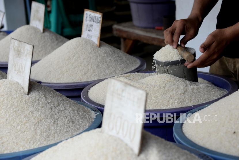 Seorang pedagang beras merapikan dagangannya di kawasan Pasar Ciputat, Tanggerang Selatan, Banten (31/1).