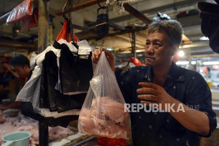 Pedagang menimbang daging ayam yang sudah dimasukan ke dalam kantong plastik (ilustrasi)